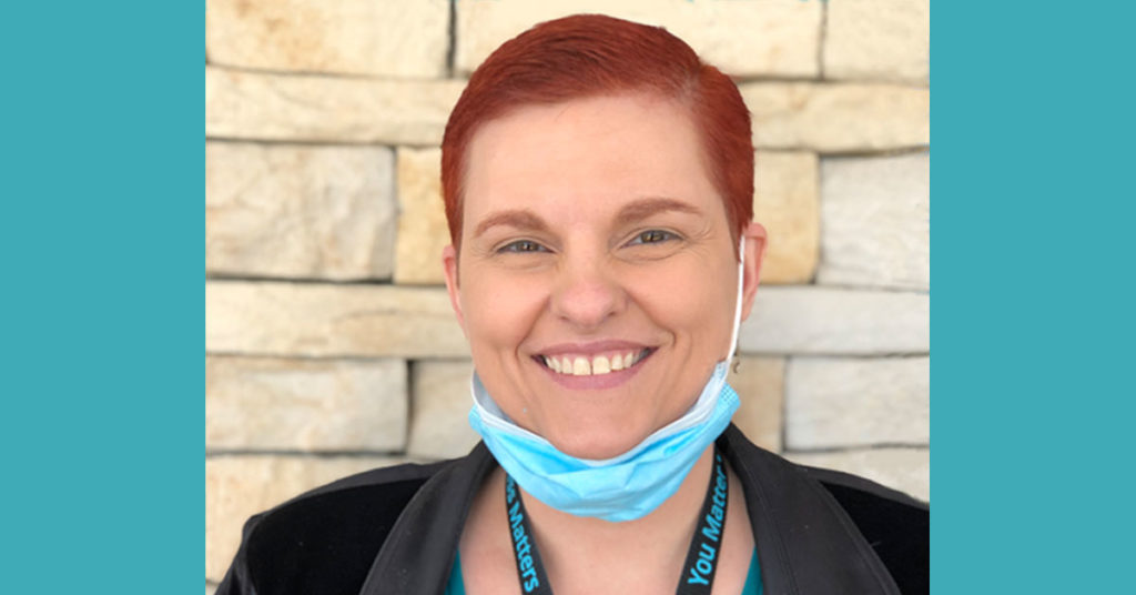 Photograph of young woman in medical scrubs and mask.